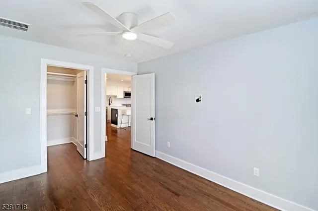 a view of a kitchen with wooden floor and a ceiling fan