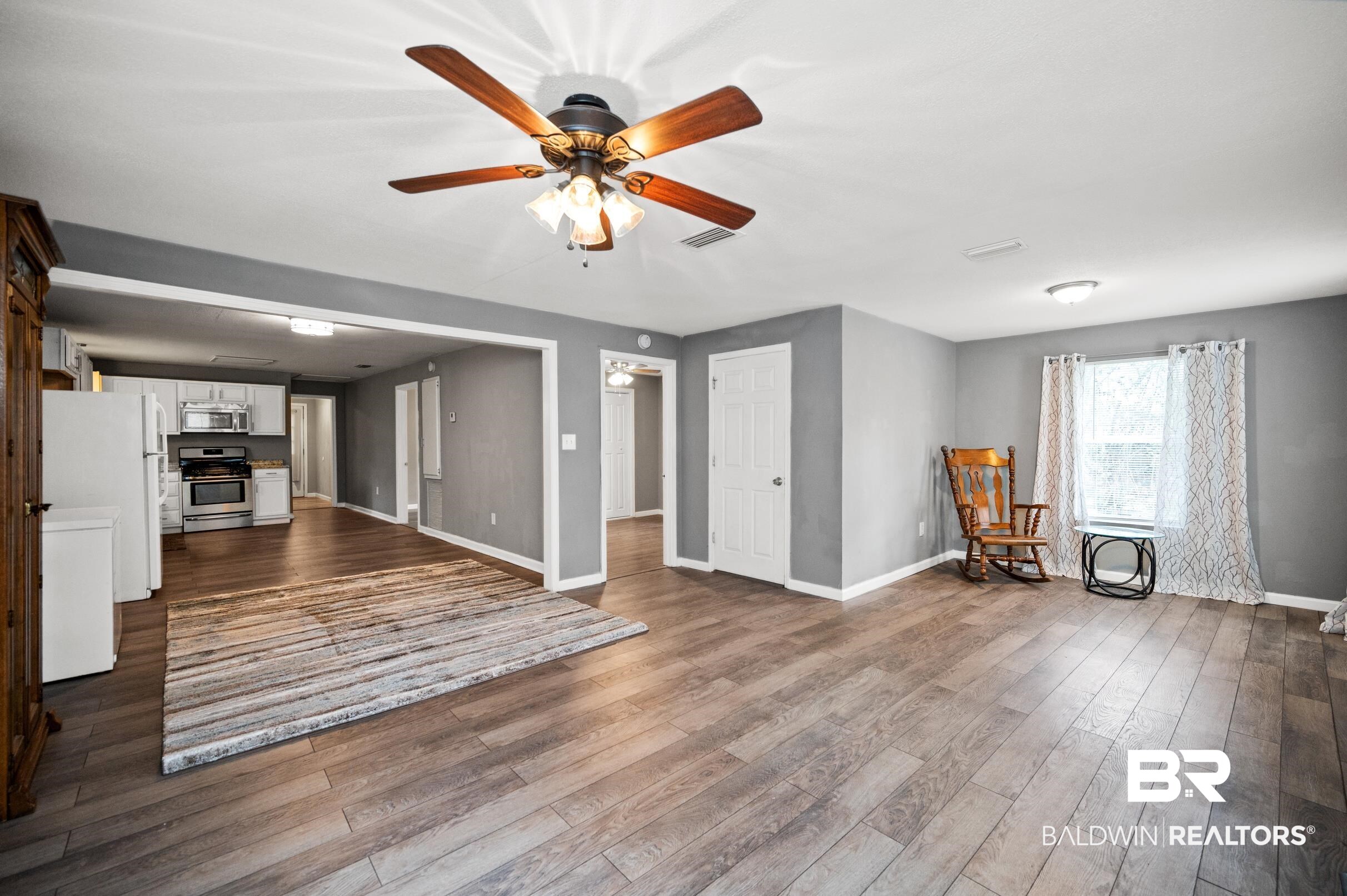 906 North Cedar Street Foley, AL 36535 - Photo 2 of 24 Unfurnished living room featuring hardwood / wood-style floors and ceiling fan
