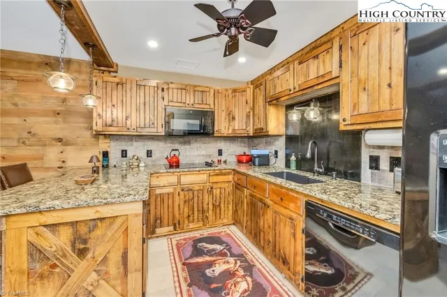 a kitchen with stainless steel appliances granite countertop a sink a stove cabinets and a dining table