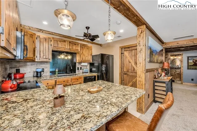 a kitchen with stainless steel appliances kitchen island granite countertop a refrigerator and microwave