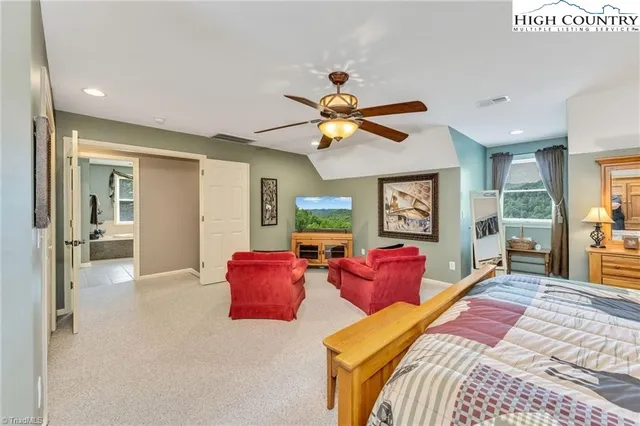 a bedroom with a bed chandelier and a window