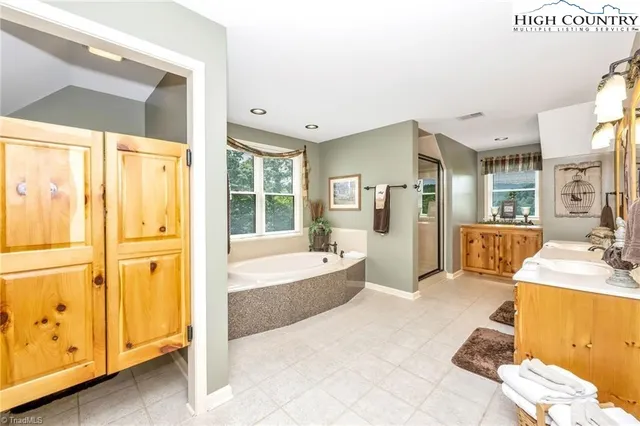 a spacious bathroom with a tub sink and mirror