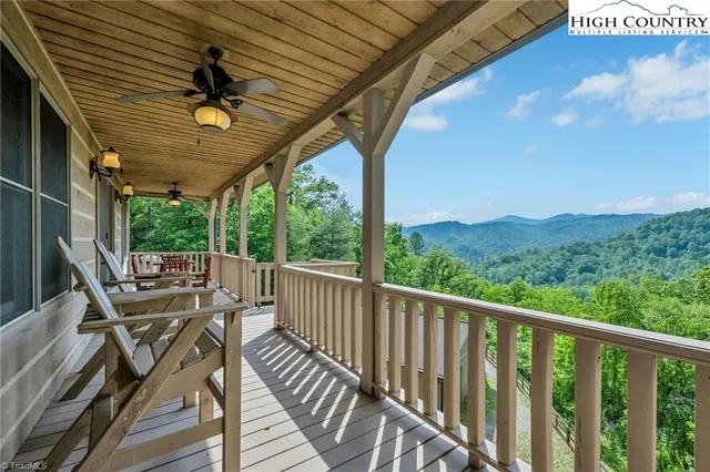 a view of a balcony with chairs and wooden fence