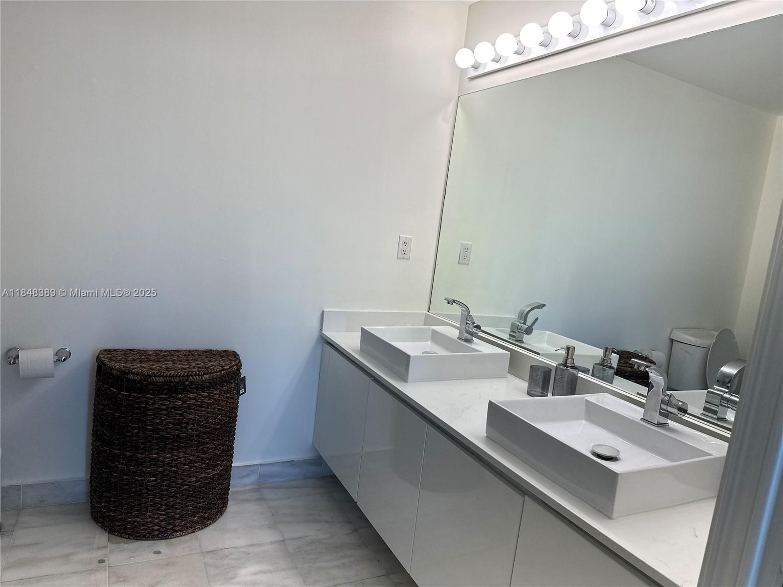 601 Northeast 36th Street, Unit 1009 Miami, FL 33137 - Photo 12 of 19 a bathroom with a sink and a mirror