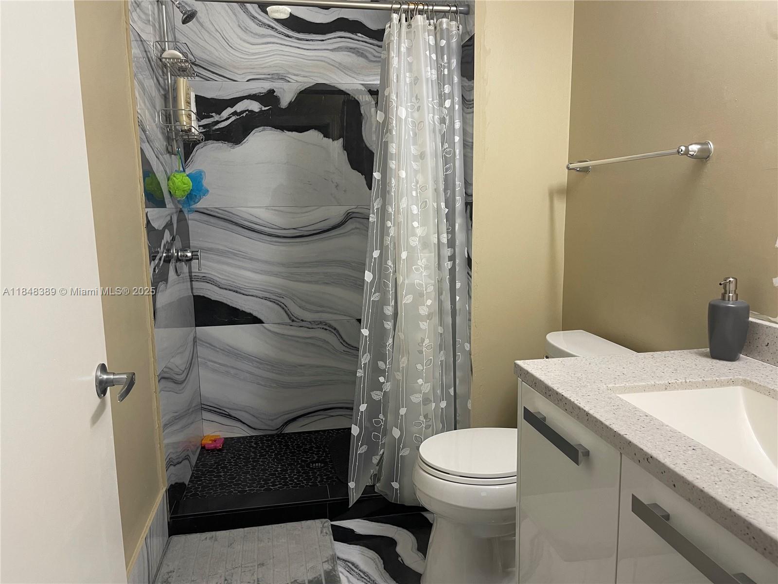 601 Northeast 36th Street, Unit 1009 Miami, FL 33137 - Photo 15 of 19 a bathroom with a sink toilet and shower