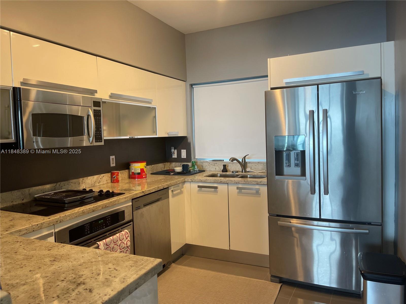 601 Northeast 36th Street, Unit 1009 Miami, FL 33137 - Photo 6 of 19 a kitchen with stainless steel appliances a refrigerator stove and microwave