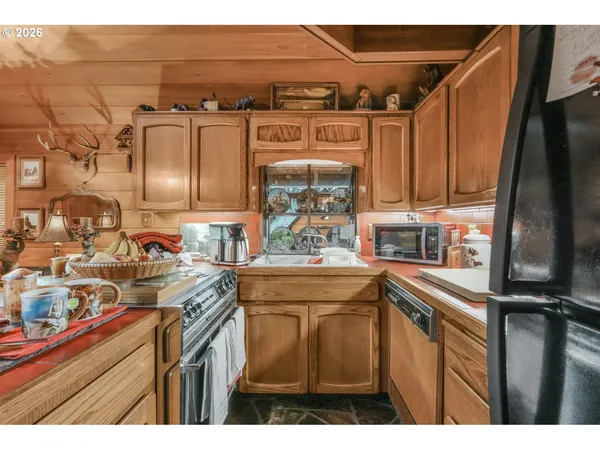 a kitchen with stainless steel appliances granite countertop a sink a stove and a refrigerator