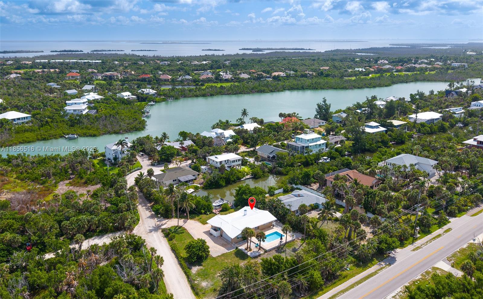 5885 Pine Tree Drive Sanibel, FL 33957 - Photo 8 of 56 an aerial view of lake and residential houses with outdoor space