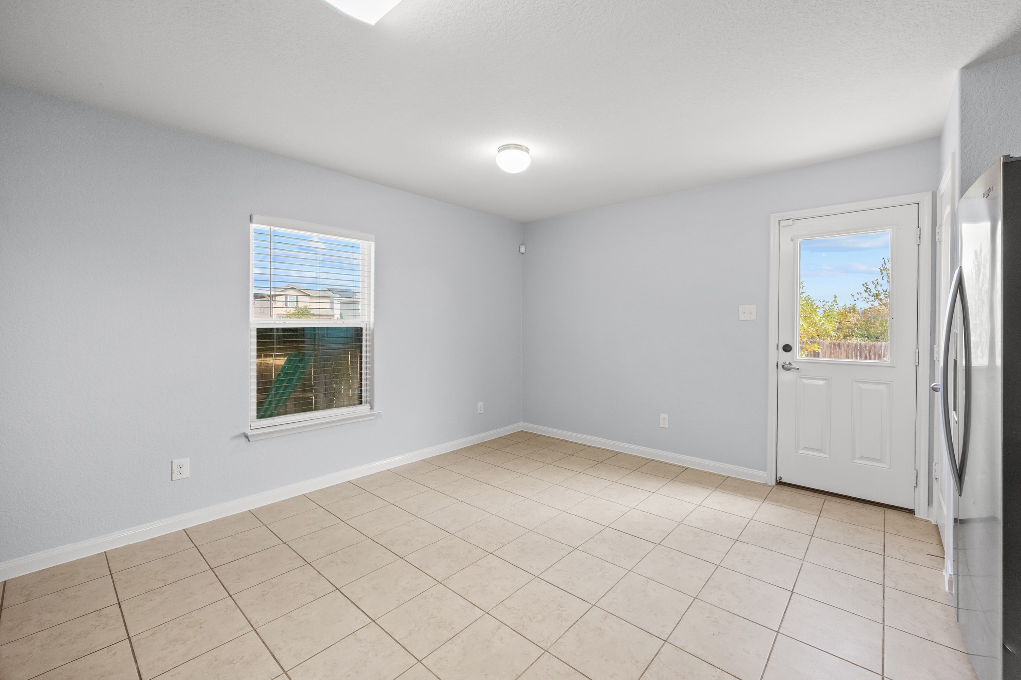 228 Millers Loop Jarrell, TX 76537 - Photo 10 of 26 Tiled flooring and a glass-inset door highlight this versatile dining area.