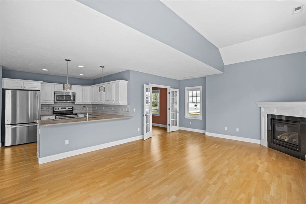 10 Mariner's Drive, Unit 10 Marshfield, MA 02050 - Photo 17 of 25 a view of kitchen with stainless steel appliances granite countertop a refrigerator oven a stove top oven with white cabinets and wooden floor
