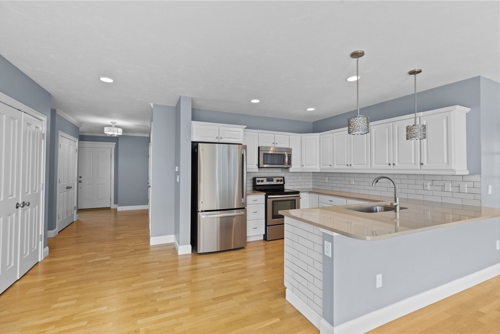 10 Mariner's Drive, Unit 10 Marshfield, MA 02050 - Photo 19 of 25 a kitchen with kitchen island a refrigerator sink and cabinets
