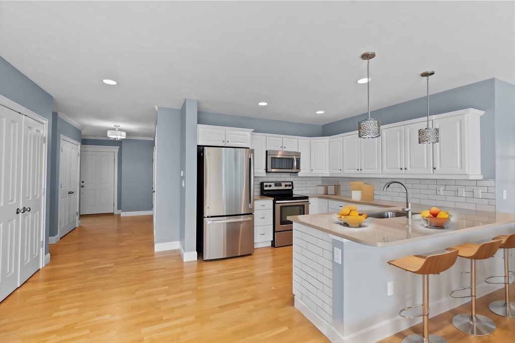 10 Mariner's Drive, Unit 10 Marshfield, MA 02050 - Photo 4 of 25 a kitchen with stainless steel appliances a refrigerator and a wooden cabinets