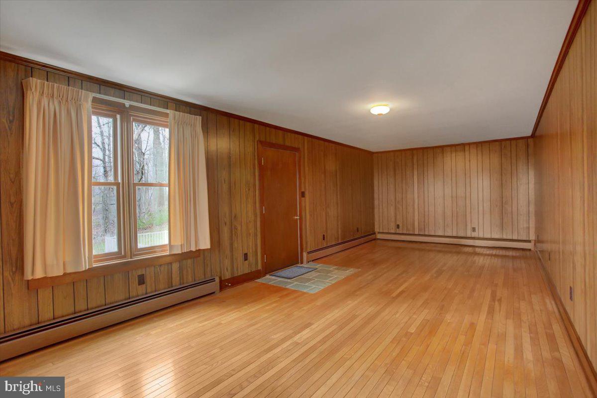 14625 Hilltop Road Cascade, MD 21719 - Photo 31 of 49 a view of an empty room with a window and wooden floor