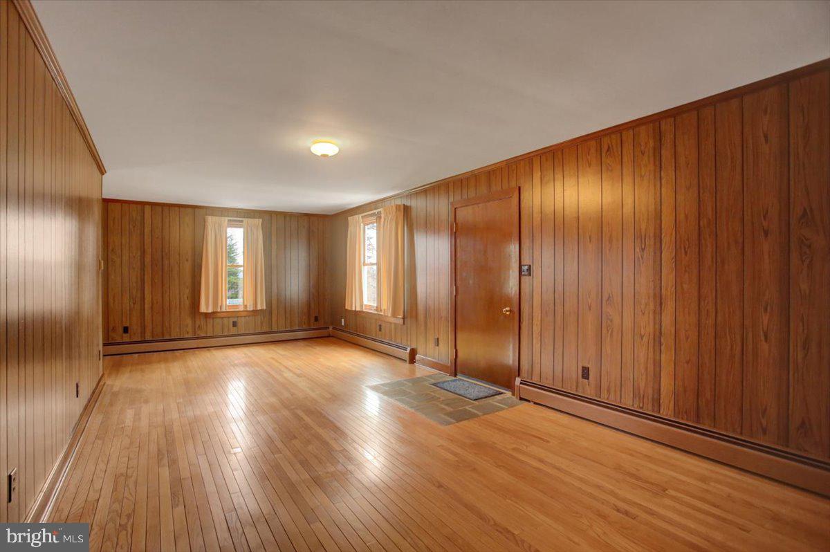 14625 Hilltop Road Cascade, MD 21719 - Photo 32 of 49 an empty room with wooden floor and windows