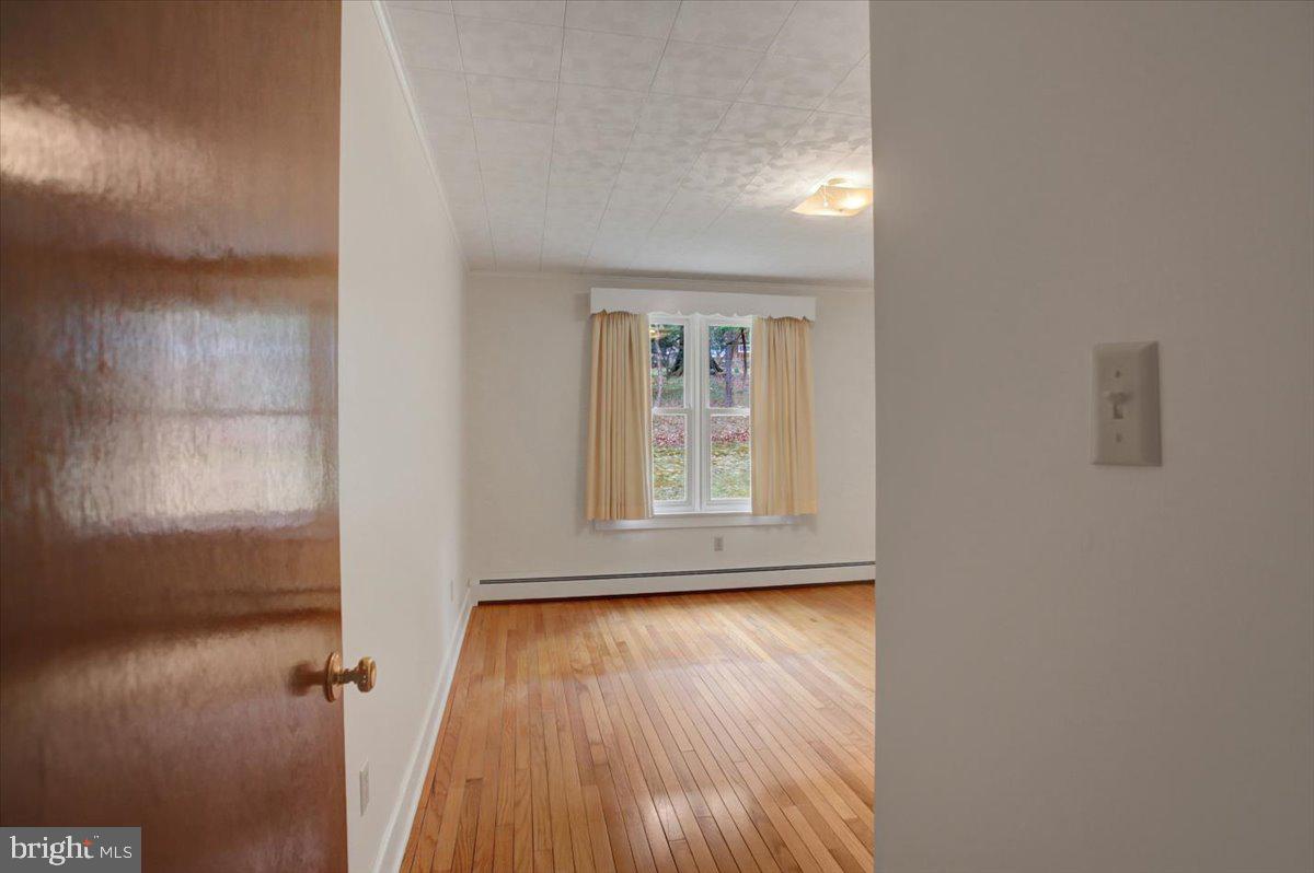 14625 Hilltop Road Cascade, MD 21719 - Photo 35 of 49 an empty room with wooden floor and a window