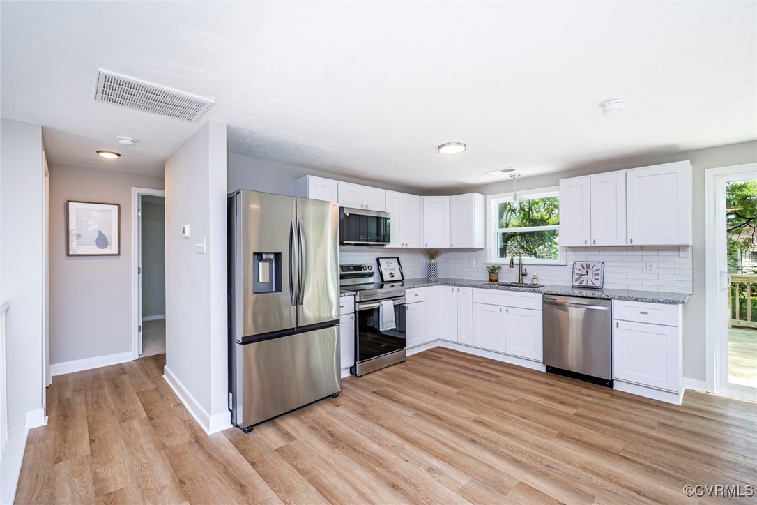 2821 Remington Road Henrico, VA 23231 - Photo 4 of 24 a kitchen with a refrigerator a stove top oven and wooden floor