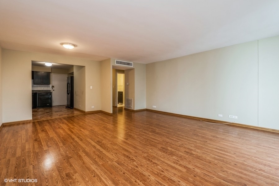 6033 North Sheridan Road, Unit 12K Chicago, IL 60660 - Photo 3 of 11 a view of an empty room with wooden floor and a window