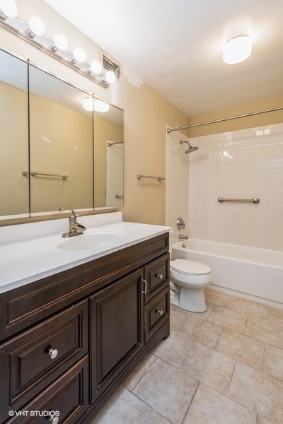 6033 North Sheridan Road, Unit 12K Chicago, IL 60660 - Photo 9 of 11 a bathroom with a granite countertop sink a toilet a mirror and shower