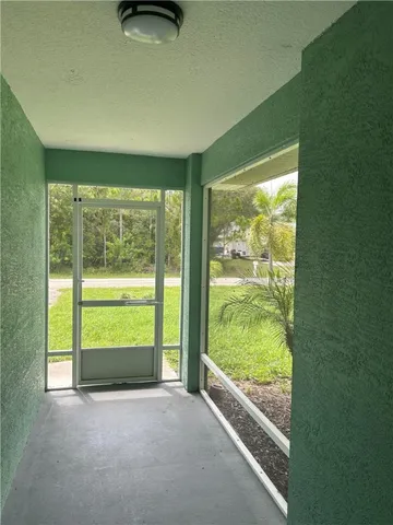 a view of an empty room with wooden floor and a floor to ceiling window