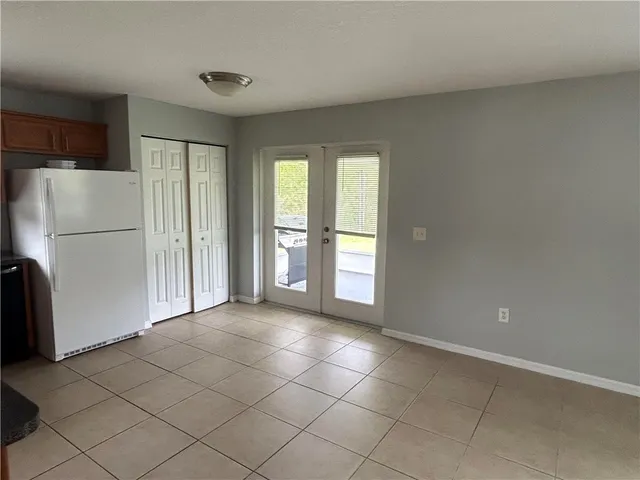 a view of a kitchen with an empty space and a refrigerator