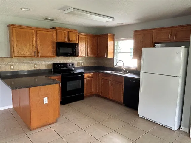 a kitchen with stainless steel appliances granite countertop a stove sink and refrigerator