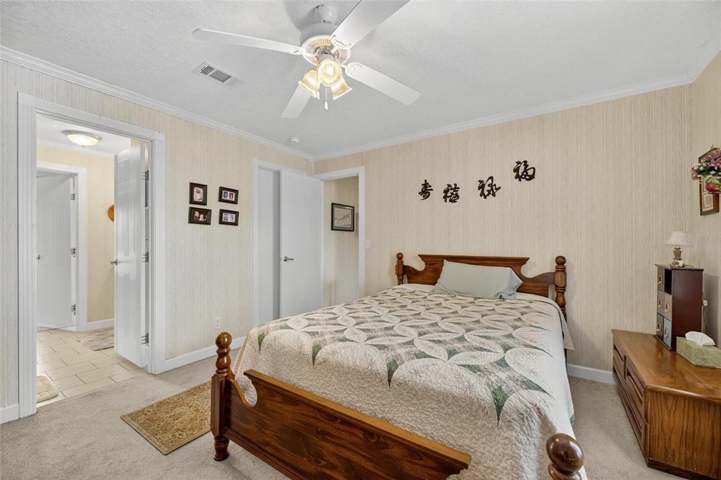 6250 Green Pond Road Polk City, FL 33868 - Photo 20 of 96 a bedroom with a bed and a chandelier