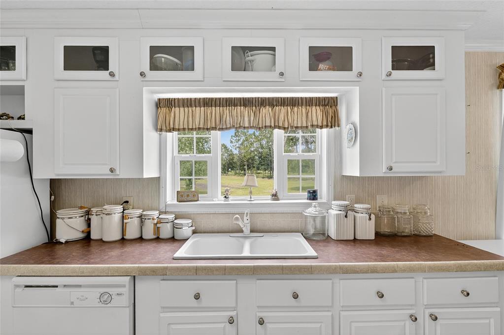 6250 Green Pond Road Polk City, FL 33868 - Photo 54 of 96 a kitchen with granite countertop a sink and a window