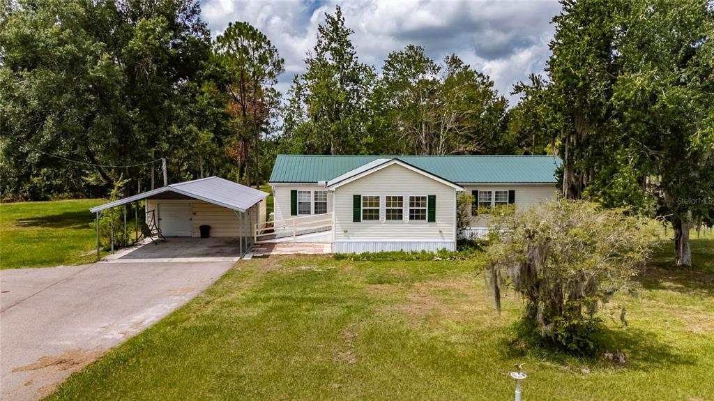 6250 Green Pond Road Polk City, FL 33868 - Photo 73 of 96 a front view of a house with a yard and garage