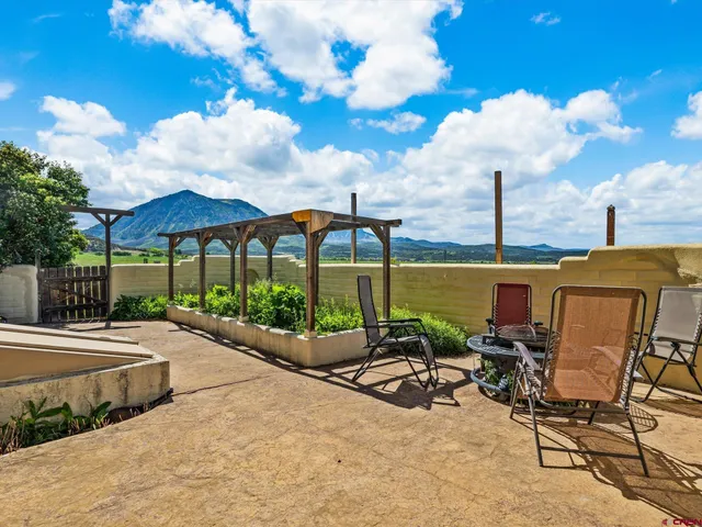 a view of a patio with a table and chairs under an umbrella