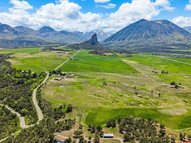 a view of a big yard with table and chairs and wooden fence