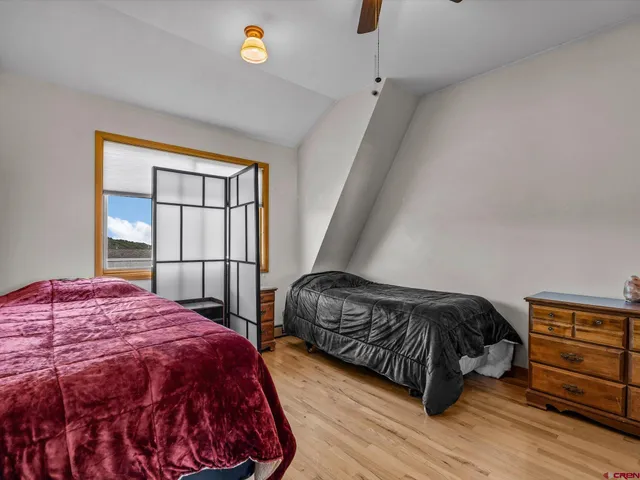 a bedroom with a bed a dresser and a window