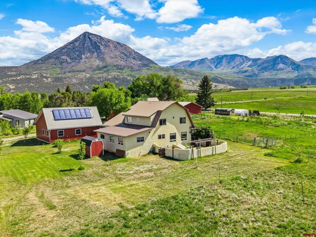 a aerial view of a house with yard and green space