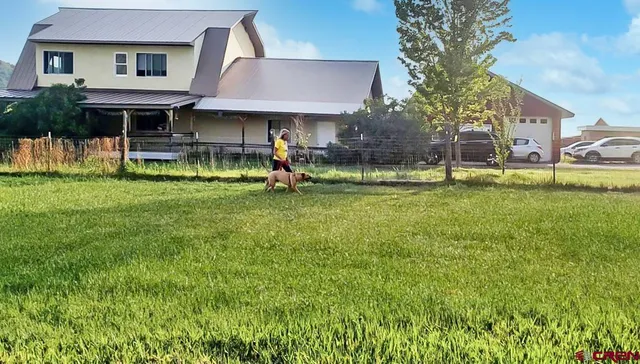 a front view of a house with a garden and trees