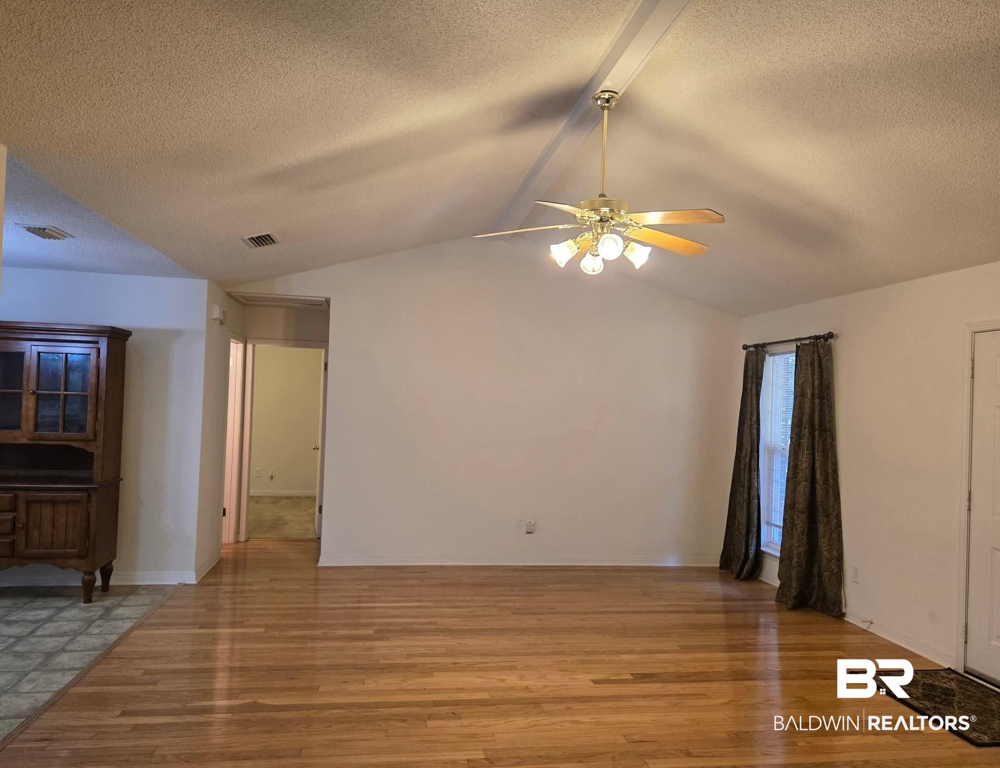 2554 Riverside Drive Mobile, AL 36605 - Photo 8 of 43 Unfurnished living room with a textured ceiling, vaulted ceiling, light wood-style flooring, and ceiling fan