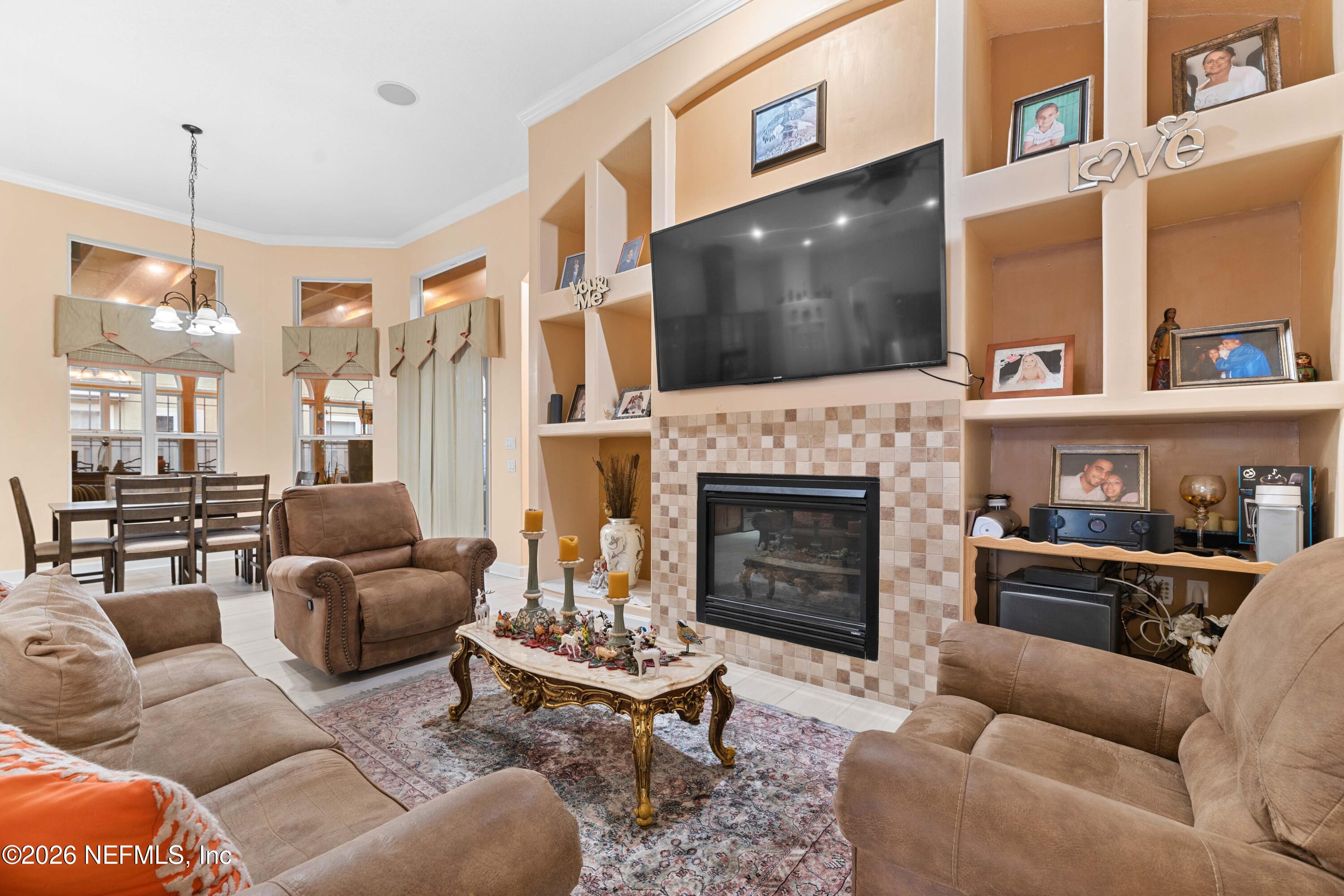 5983 Wakulla Springs Road Jacksonville, FL 32258 - Photo 5 of 31 a living room with furniture a flat screen tv and a fireplace