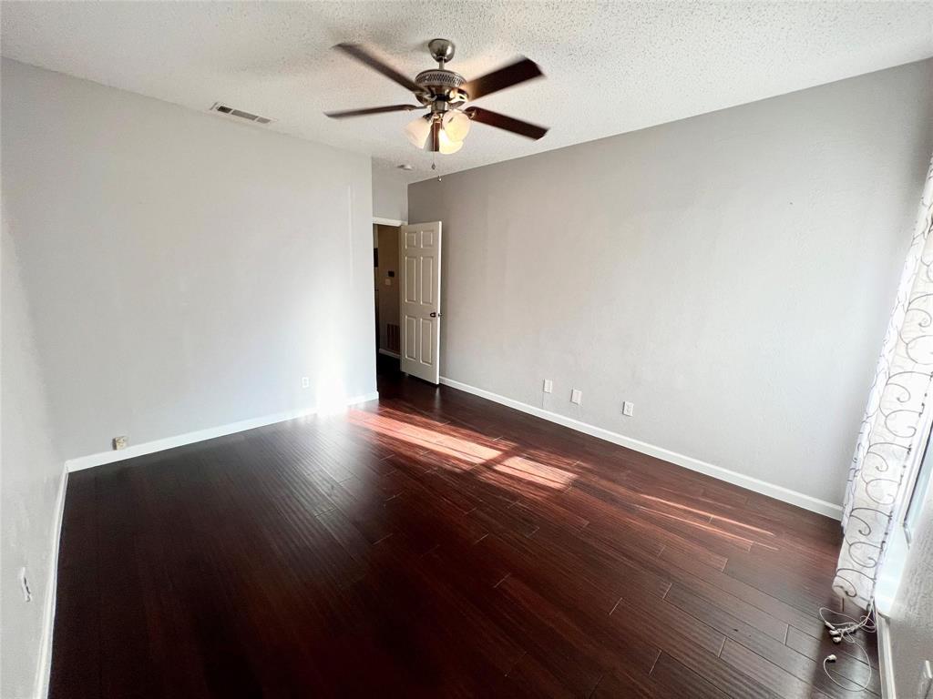 2105 Count Fleet Drive, Unit 207 Arlington, TX 76011 - Photo 13 of 17 an empty room with wooden floor and windows