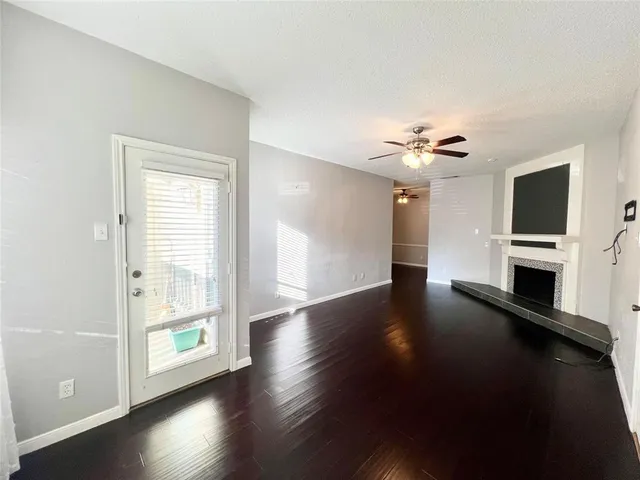 a view of empty room with wooden floor and fireplace