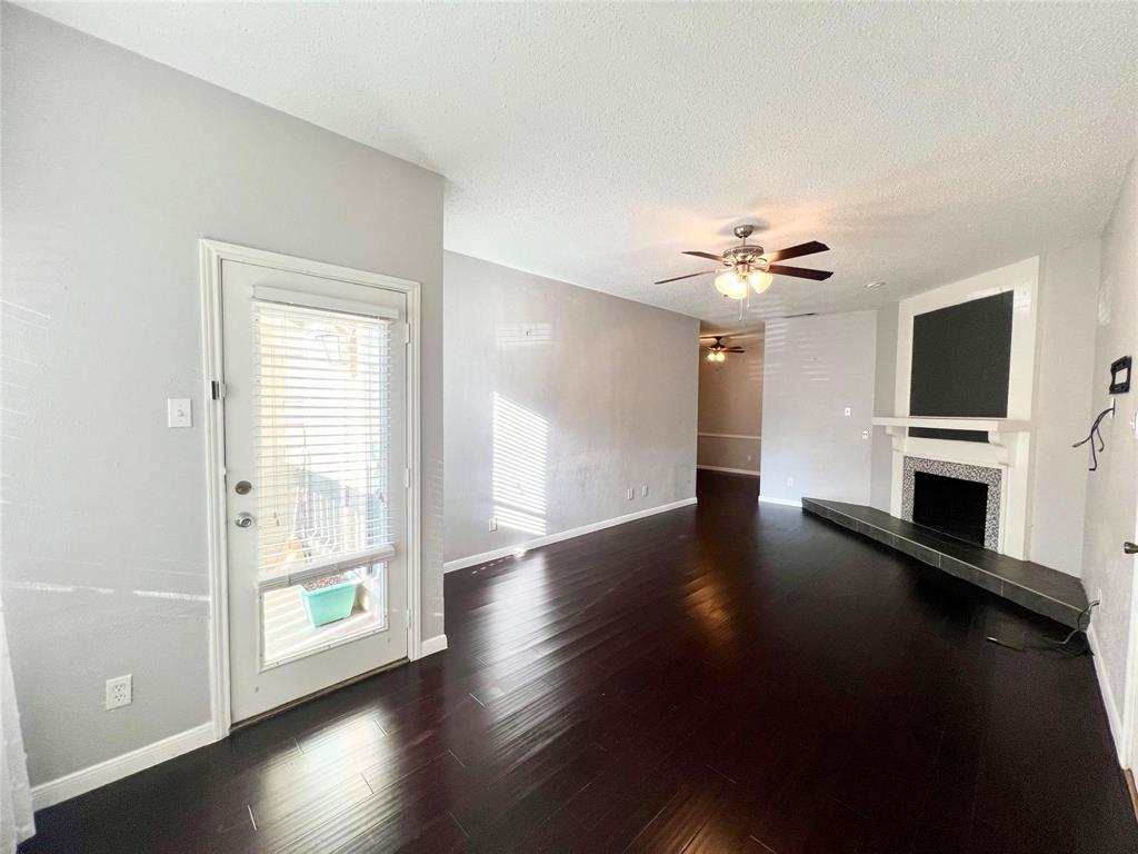 2105 Count Fleet Drive, Unit 207 Arlington, TX 76011 - Photo 3 of 17 a view of empty room with wooden floor and fireplace