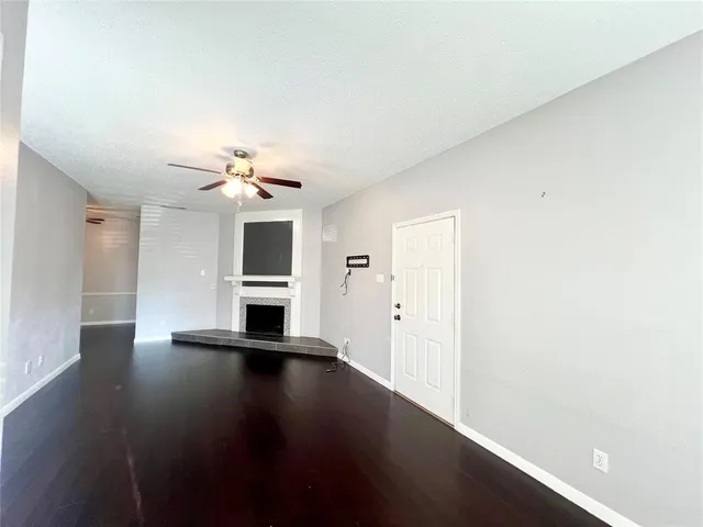 a view of a livingroom with wooden floor and a ceiling fan