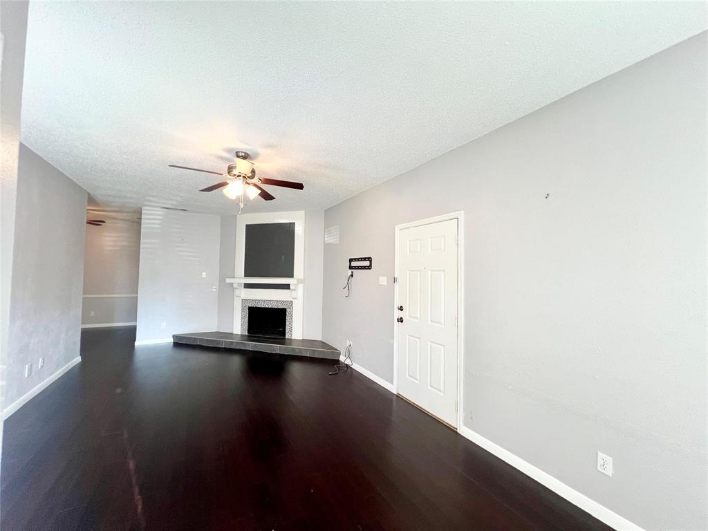 2105 Count Fleet Drive, Unit 207 Arlington, TX 76011 - Photo 5 of 17 a view of a livingroom with wooden floor and a ceiling fan