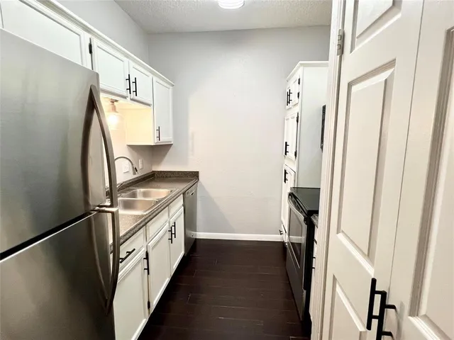 a kitchen with stainless steel appliances granite countertop a refrigerator and a sink