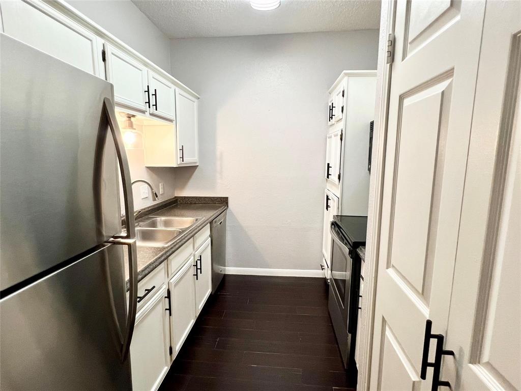 2105 Count Fleet Drive, Unit 207 Arlington, TX 76011 - Photo 7 of 17 a kitchen with stainless steel appliances granite countertop a refrigerator and a sink