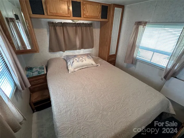 a bed sitting in a bedroom next to a window