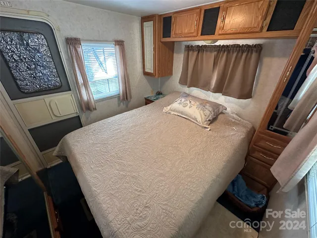 a bed sitting in a bedroom next to a window