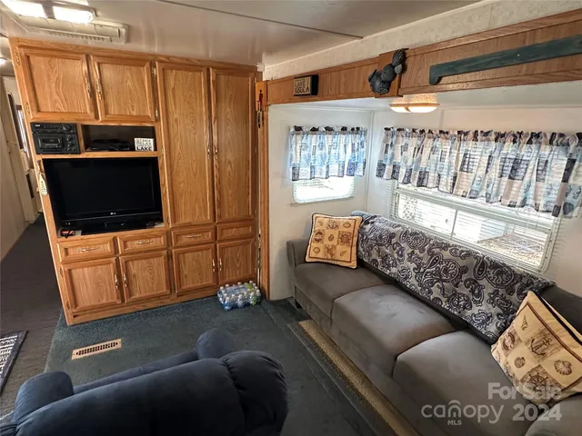 a living room with furniture a flat screen tv and a window