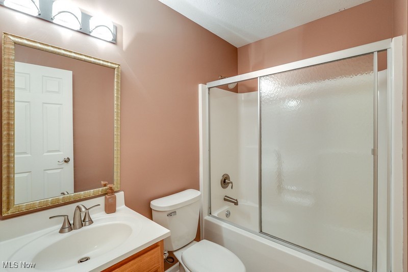 8648 Taylor May Road Chagrin Falls, OH 44023 - Photo 25 of 37 Full bathroom featuring combined bath / shower with glass door, toilet, a textured ceiling, and vanity