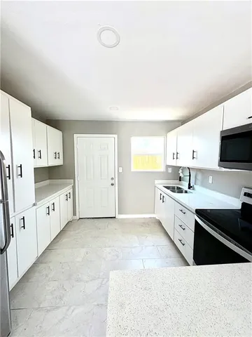 a large white kitchen with cabinets