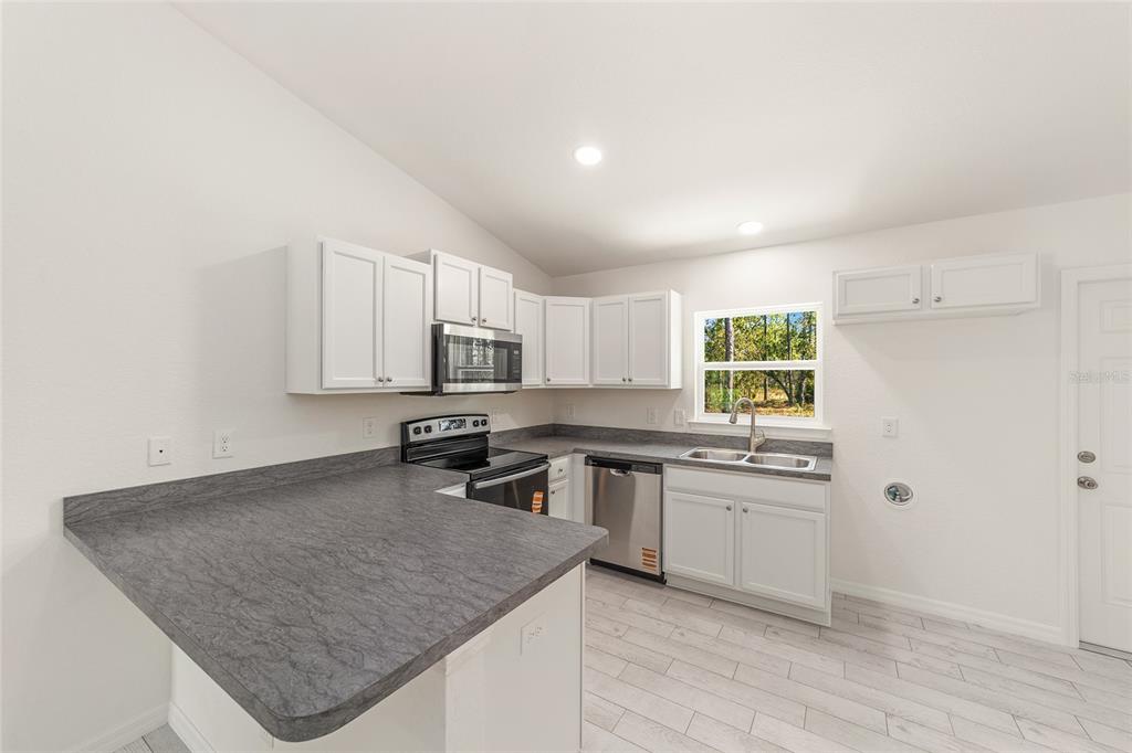 284 Southwest Commodore Road Dunnellon, FL 34431 - Photo 18 of 48 a kitchen with stainless steel appliances granite countertop a sink stove and cabinets