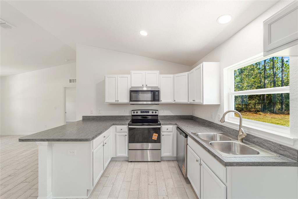 284 Southwest Commodore Road Dunnellon, FL 34431 - Photo 19 of 48 a kitchen with stainless steel appliances granite countertop a sink stove and refrigerator