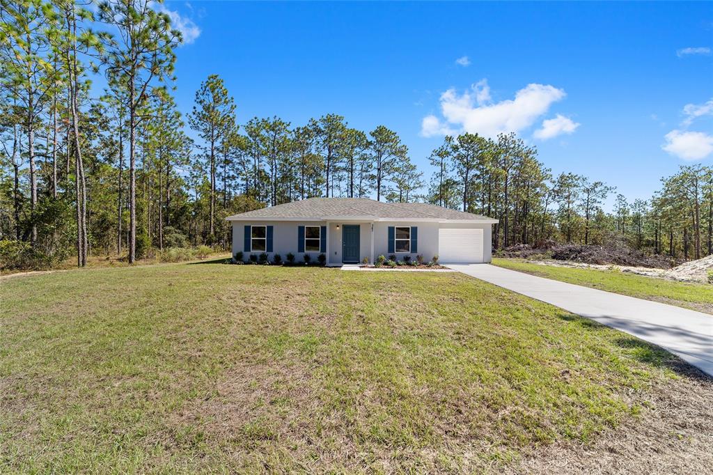 284 Southwest Commodore Road Dunnellon, FL 34431 - Photo 5 of 48 a front view of house with yard and trees in the background